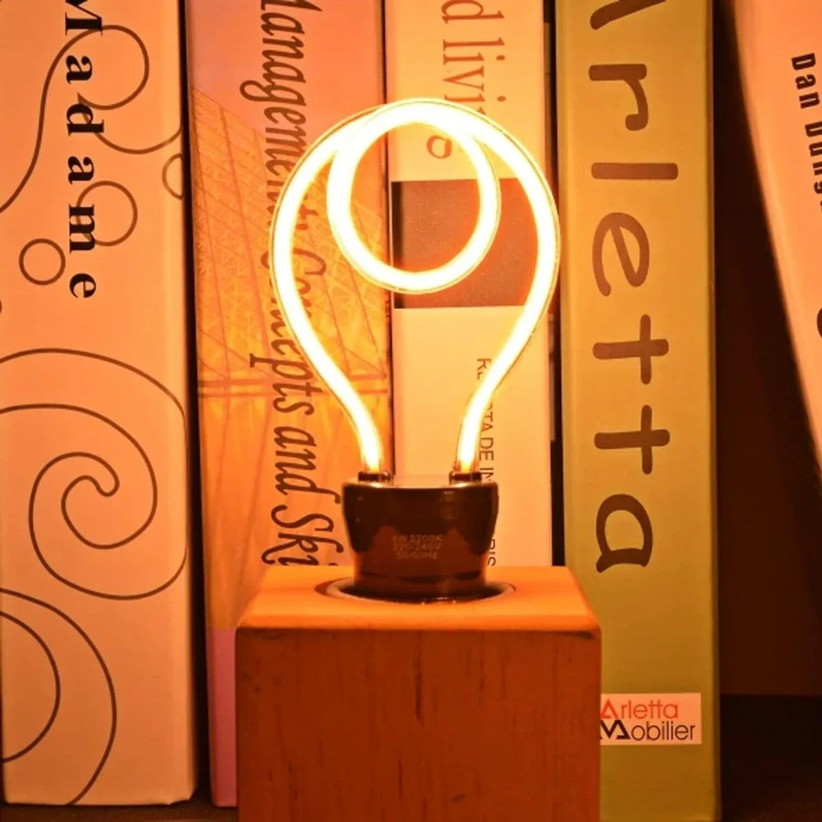 Vintage LED filament bulb with neon-style curved filament in clear polycarbonate E27 screw fitting glowing amber light