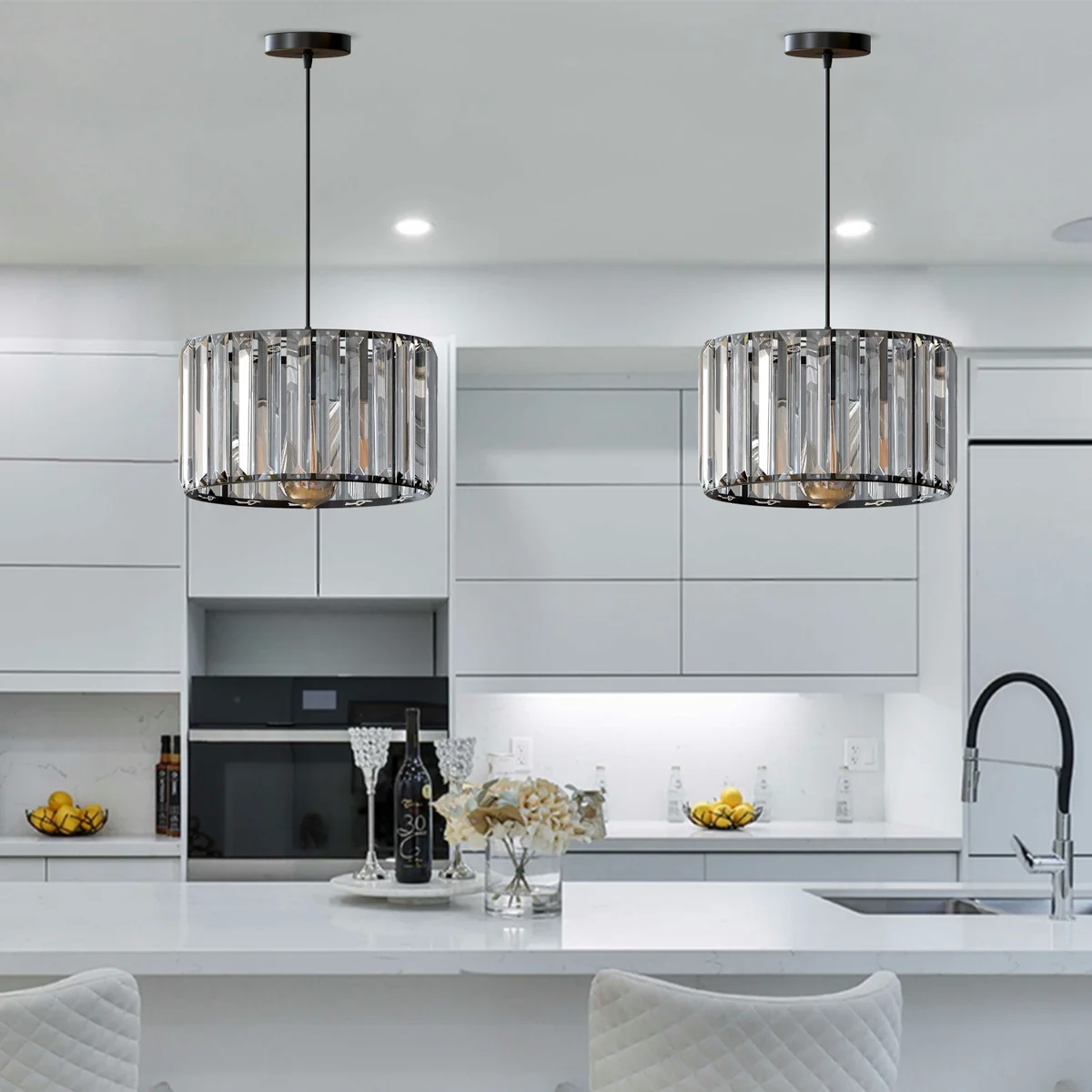 Modern crystal pendant light with drum-shaped crystal shade and metal holder, hanging from ceiling.