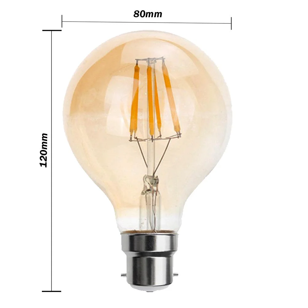 G80 LED bulb with amber antique filament, B22 base, glowing softly against a white background.
