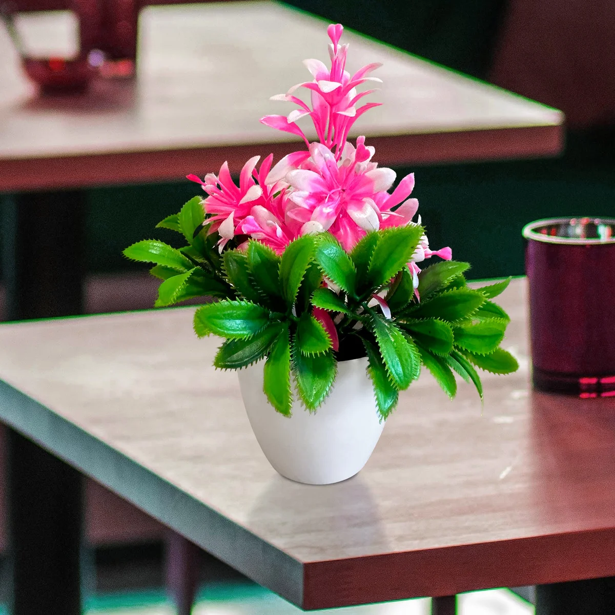 Bright artificial flower plants in small plastic pot with green leaves, ideal for indoor decoration and low maintenance