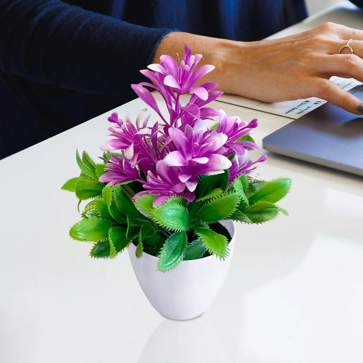 Bright artificial flowers in a small plastic pot, perfect low maintenance plants for indoor decor with lush green leaves