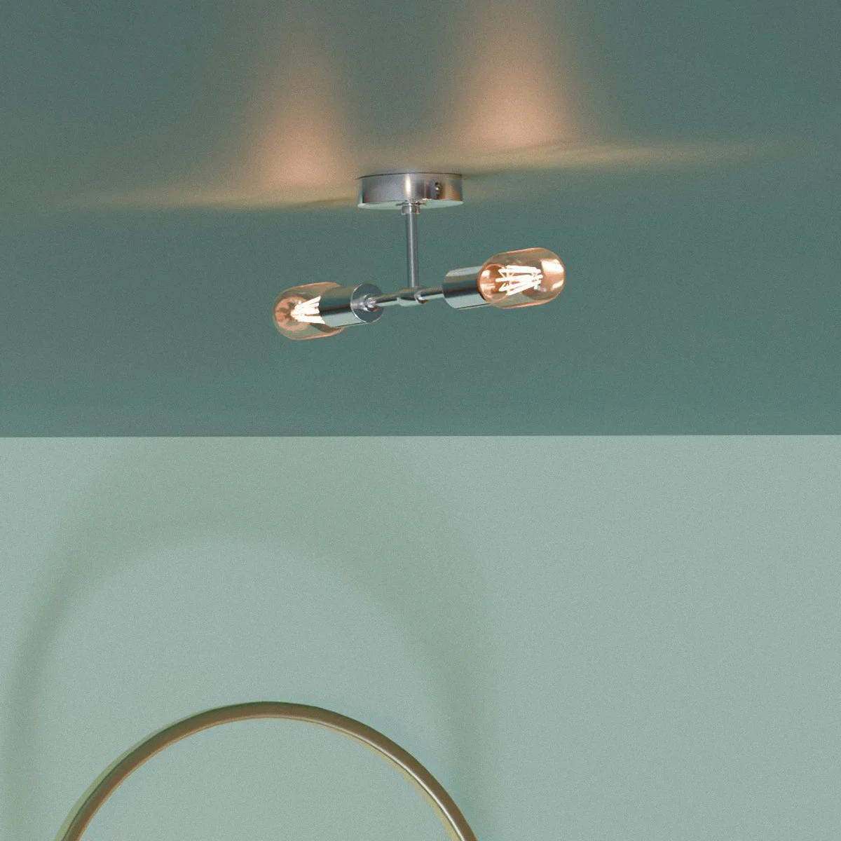 Dual socket ceiling light in polished metal finish mounted on wall, showing two E27 bulb sockets and sleek industrial design