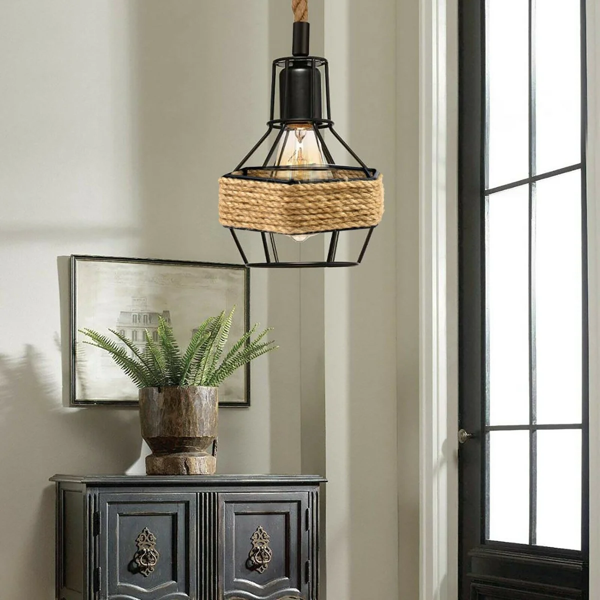 Black metal pendant lamp with hemp rope and industrial light cage hanging from ceiling plate against white background