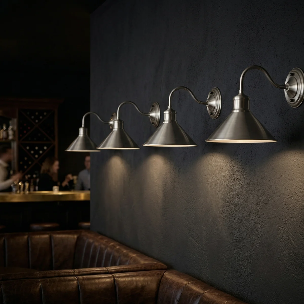 Industrial wall sconce with 22cm wide conical metal shade and curved arm in matte black finish mounted on a wall