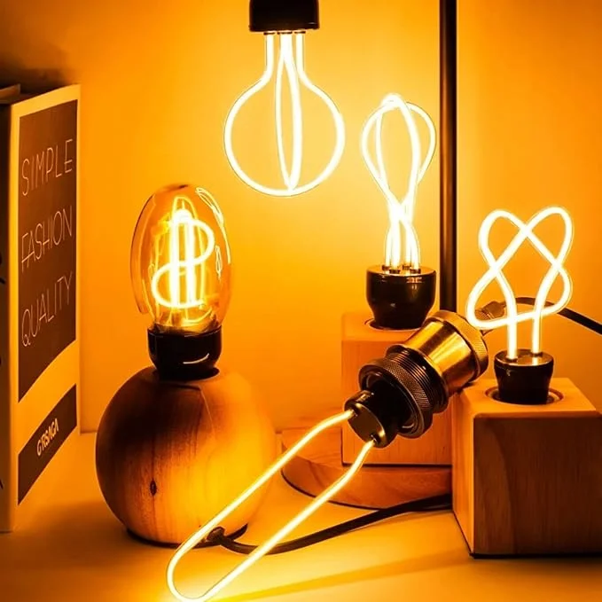 Retro vintage flexible LED filament bulb glowing warm yellow LED bulb with E27 Edison screw fitting on display