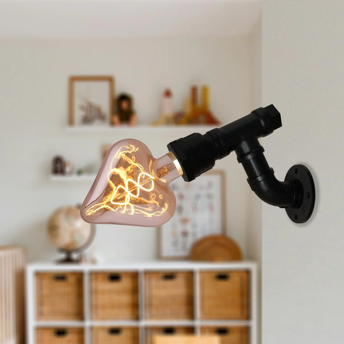 Vintage industrial wall light with black metal steampunk water pipe design mounted on a white indoor wall