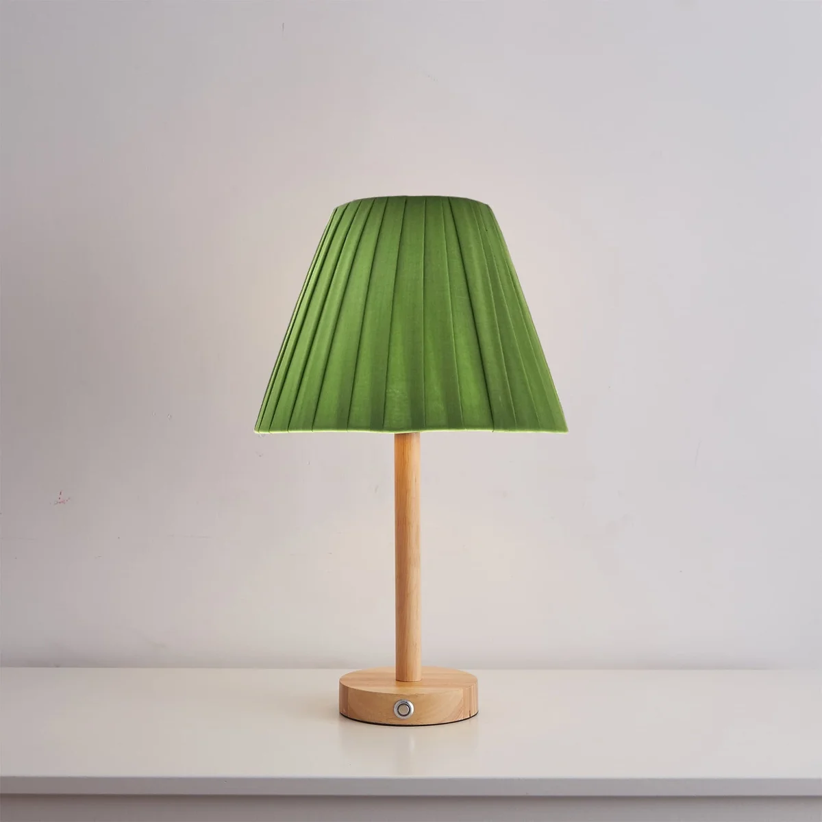 Modern table lampshade in coolie shape with white fabric and plastic lining, shown on a wooden surface indoors