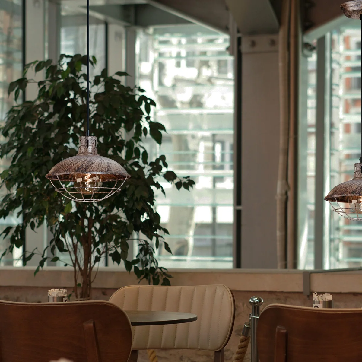 Nautical pendant light with polished metal cage and adjustable cord hanging from ceiling against white background