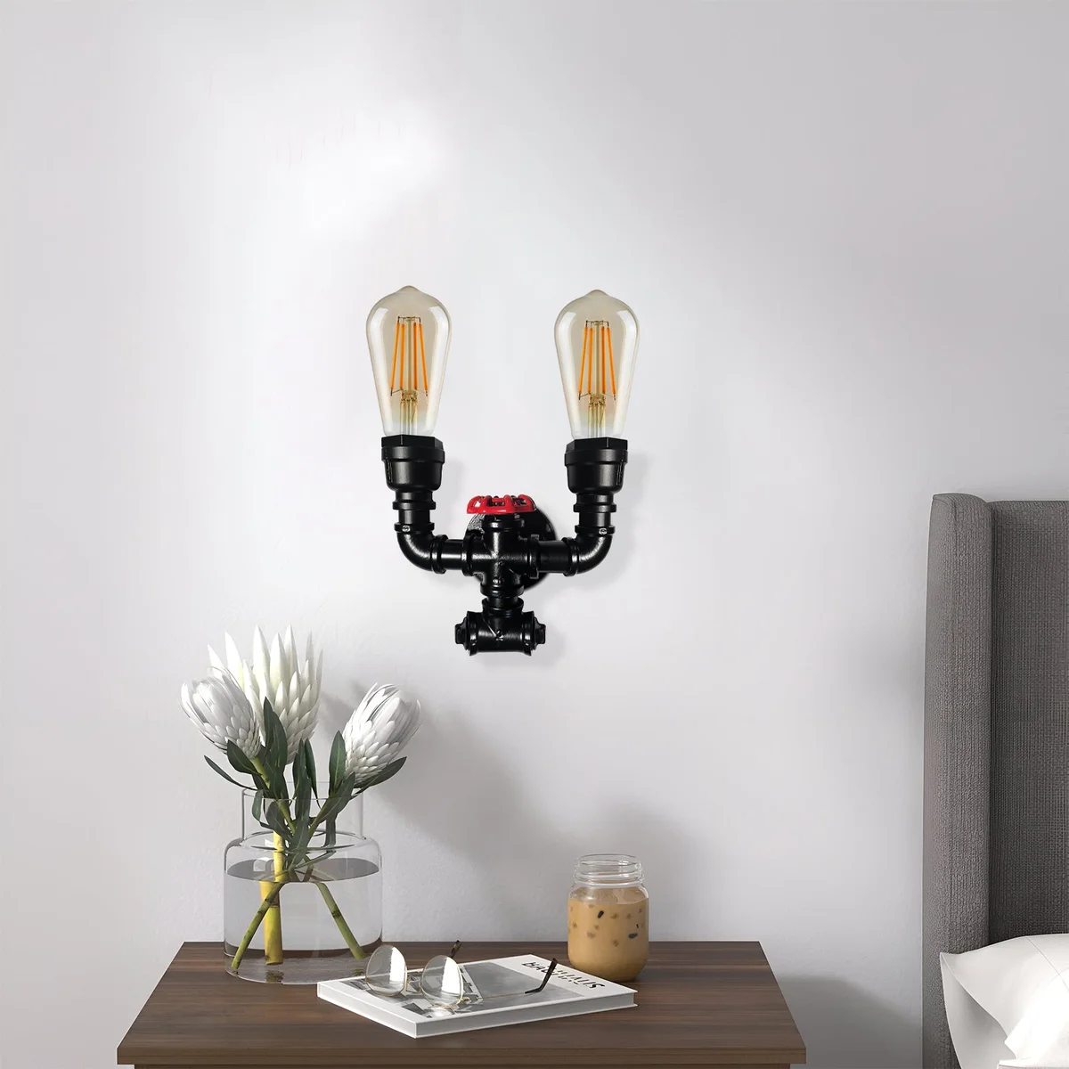 Vintage wall light featuring twin water pipe design with black metal frame and red valve, mounted on wall
