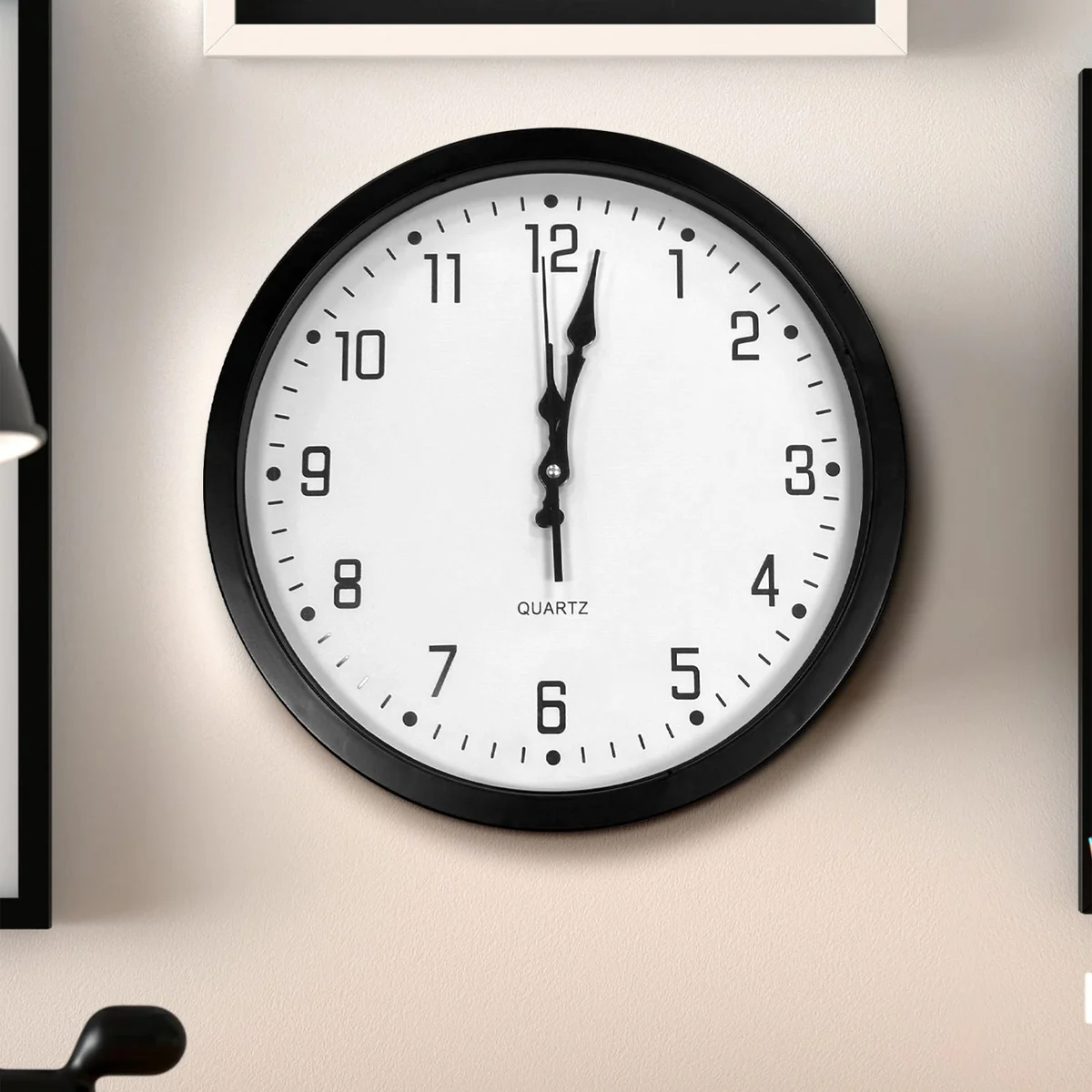 Modern round indoor wall clock with black plastic frame and large white analog numbers on black dial, 35cm diameter