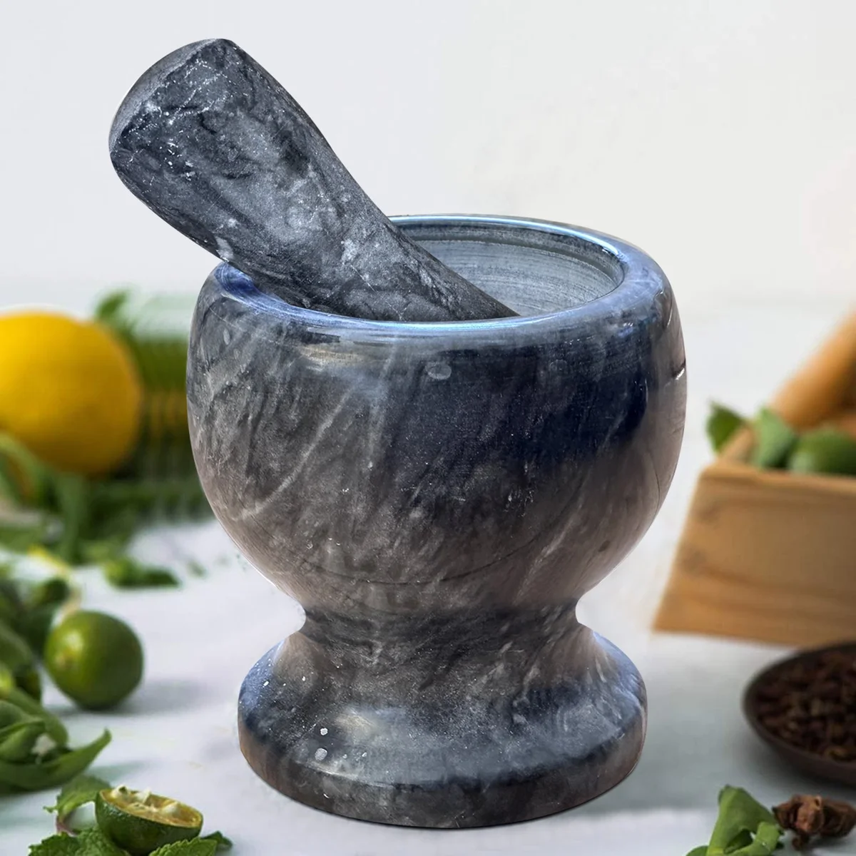 Polished marble pestle resting inside matching marble mortar on a white background for grinding herbs and spices