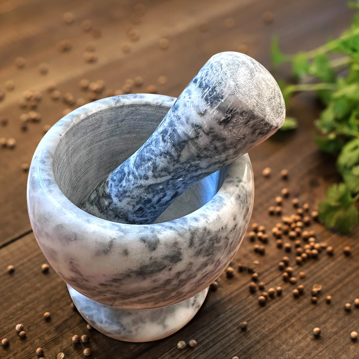 Polished marble mortar and pestle set shown as a compact kitchen utensil for grinding herbs and spices