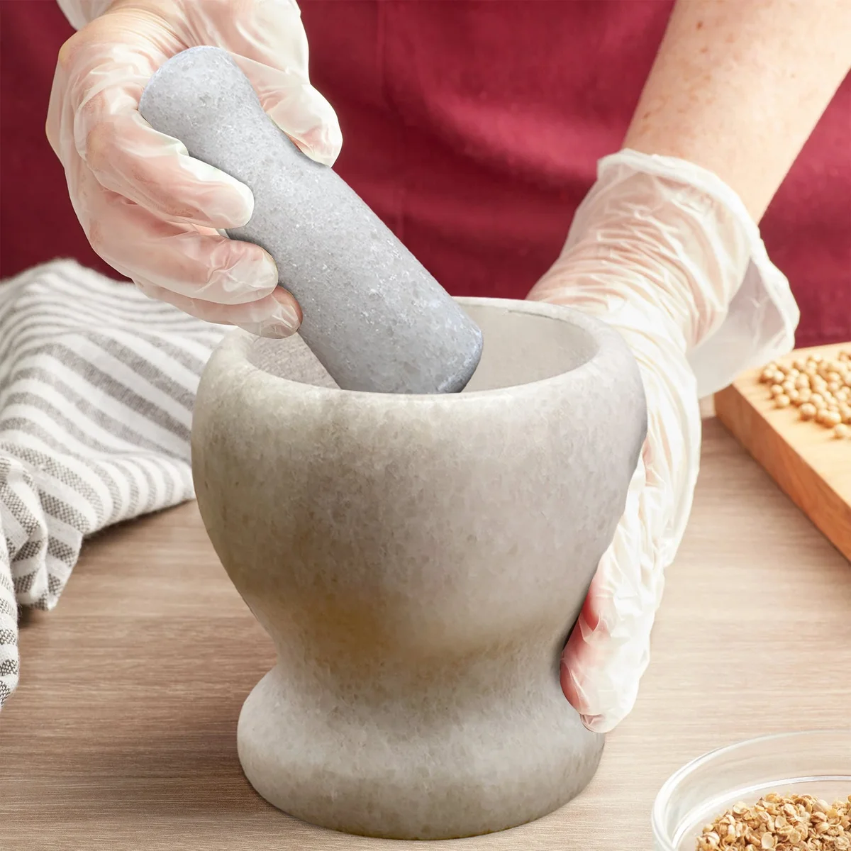 Polished marble herb crusher set with mortar and pestle, displayed in a kitchen setting, making a foodie kitchen gift