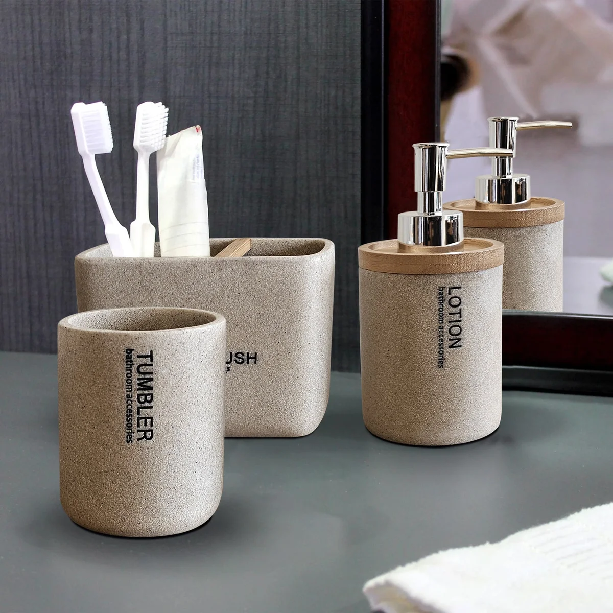 Modern bathroom accessory set with stone effect resin lotion dispenser, toothbrush holder, and tumbler in neutral tones