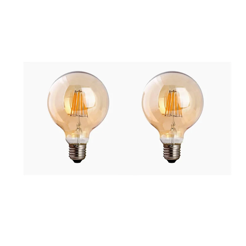 Amber glass vintage dimmable LED bulb G95 with E27 screw base, glowing softly against dark background