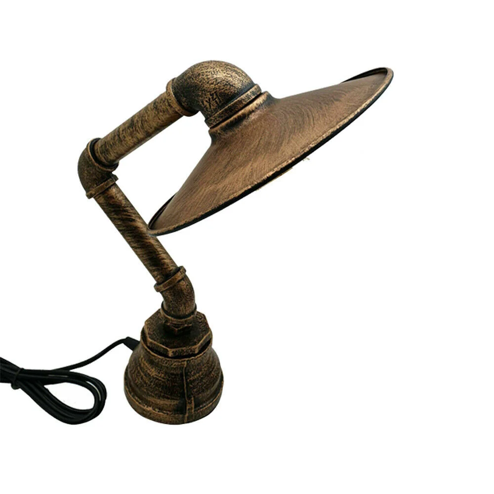 Steampunk table lamp with vintage industrial copper pipe design and flat metal lampshade on wooden surface