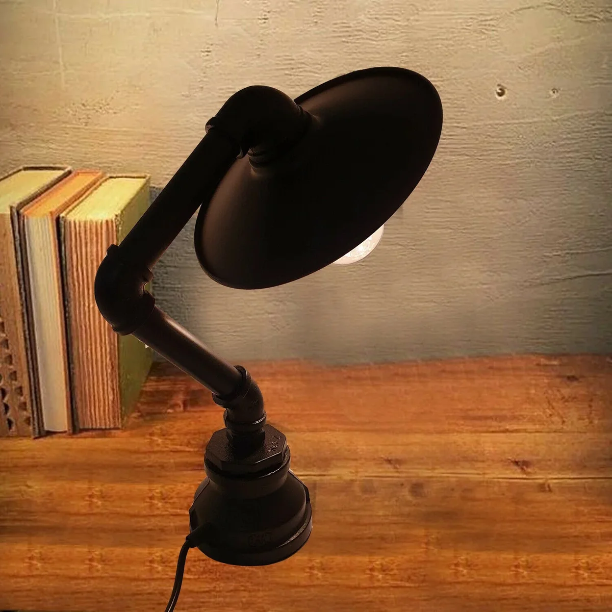 Industrial style lamp with vintage copper pipe design and flat metal lampshade on a wooden surface background