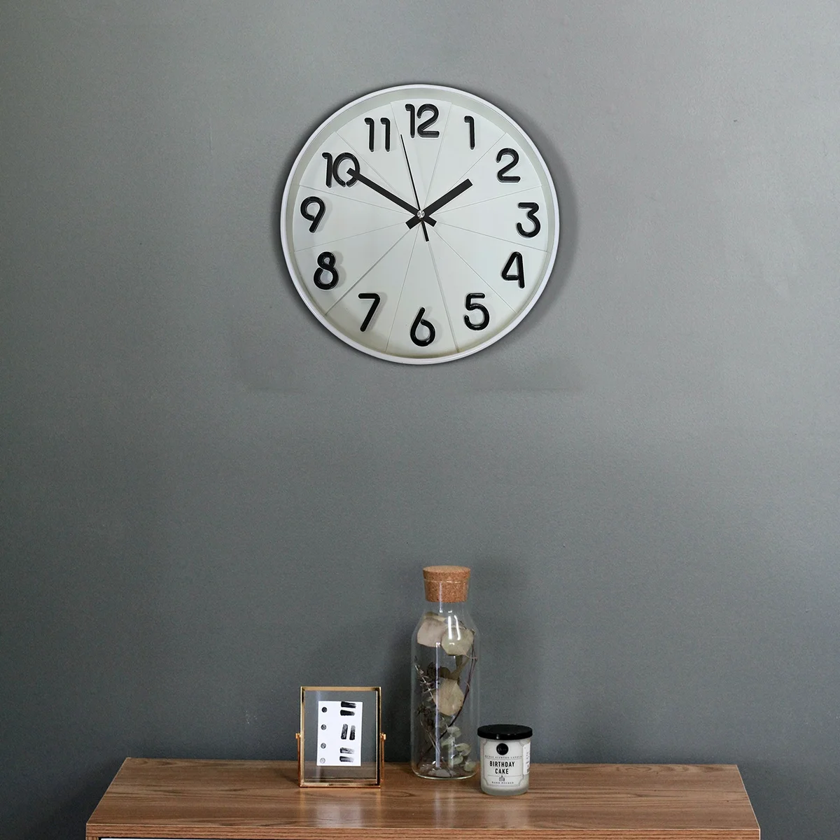 Round wall clock with black background, white numbers and hands, silent non-ticking, plastic frame with tempered glass face