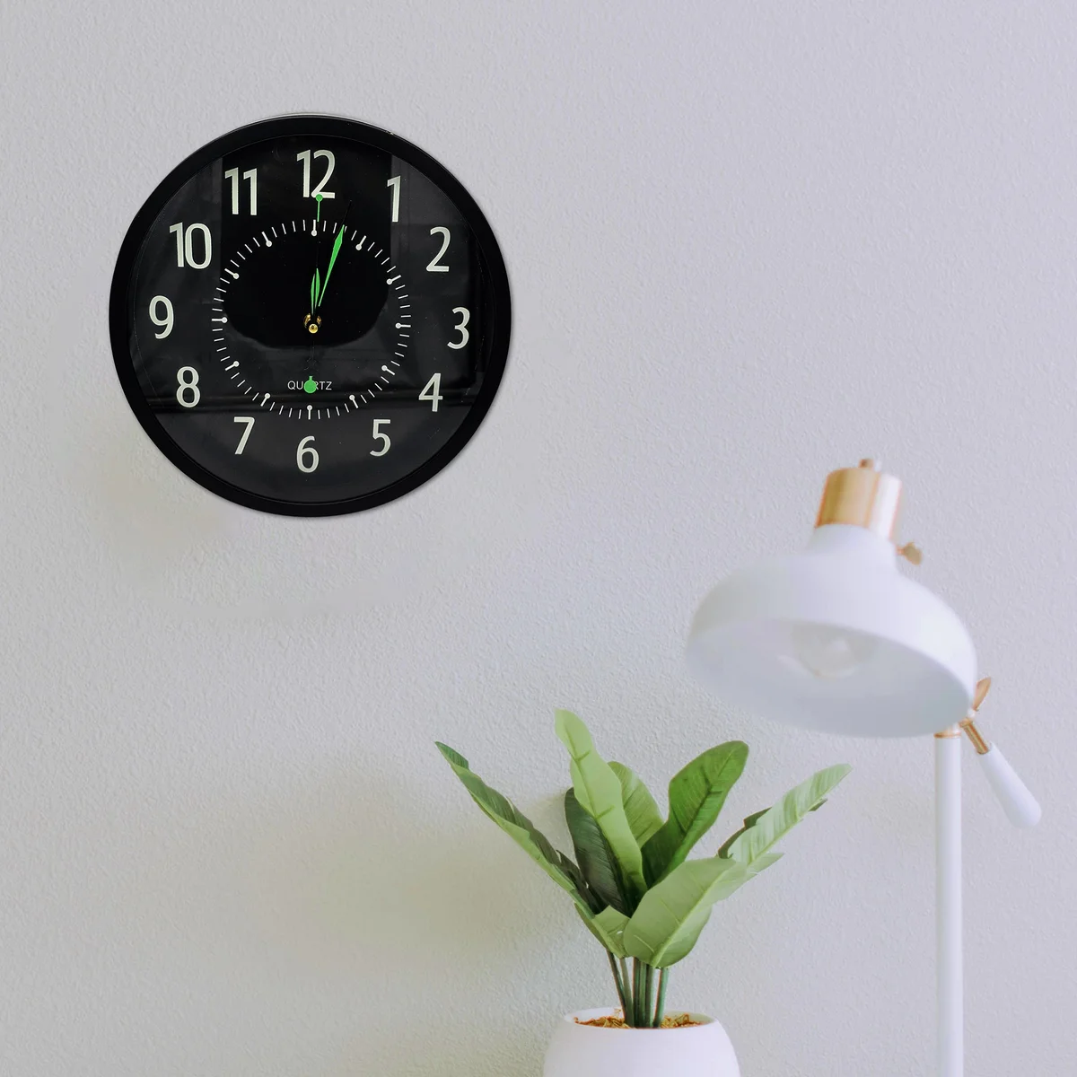 Black wall clock with round shape, black background, white numbers and hands, silent non-ticking design, tempered glass face