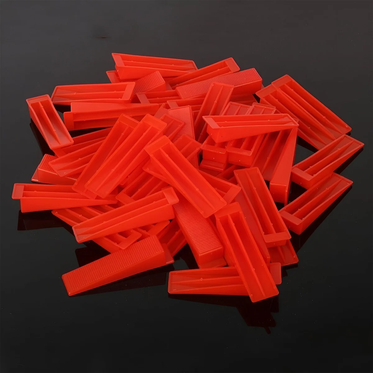 Set of 100 yellow, red, and orange PVC floor tile tools shaped as T-wedges for leveling and spacing tiles during installation