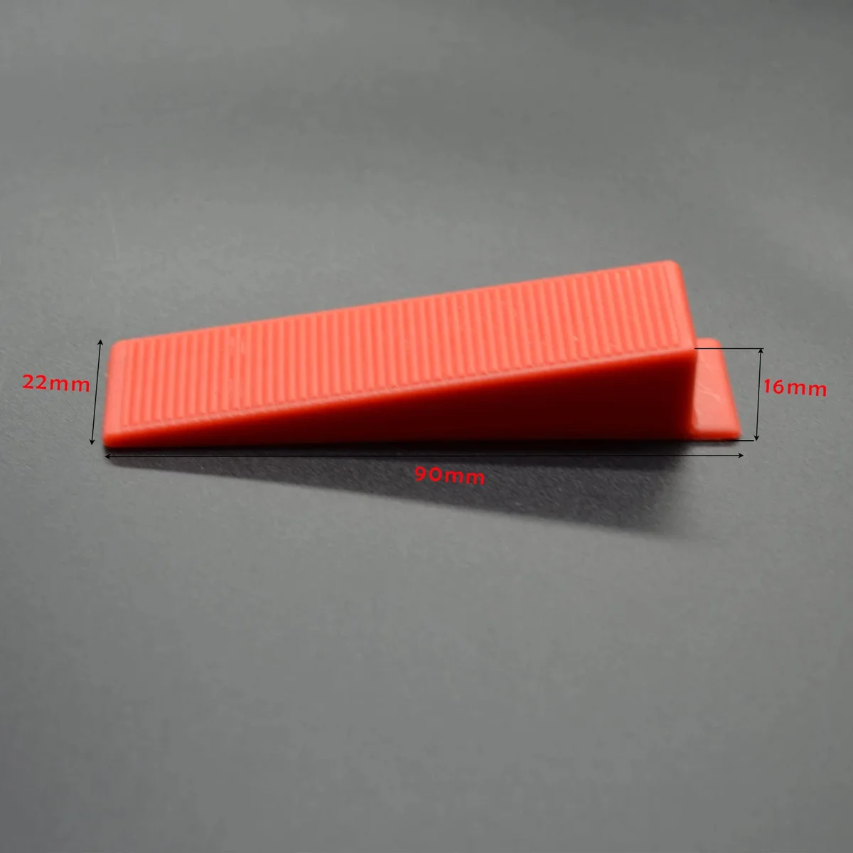 Set of 100 yellow, red, and orange reusable PVC tile leveling wedges, essential professional tiling tools for even tile installation