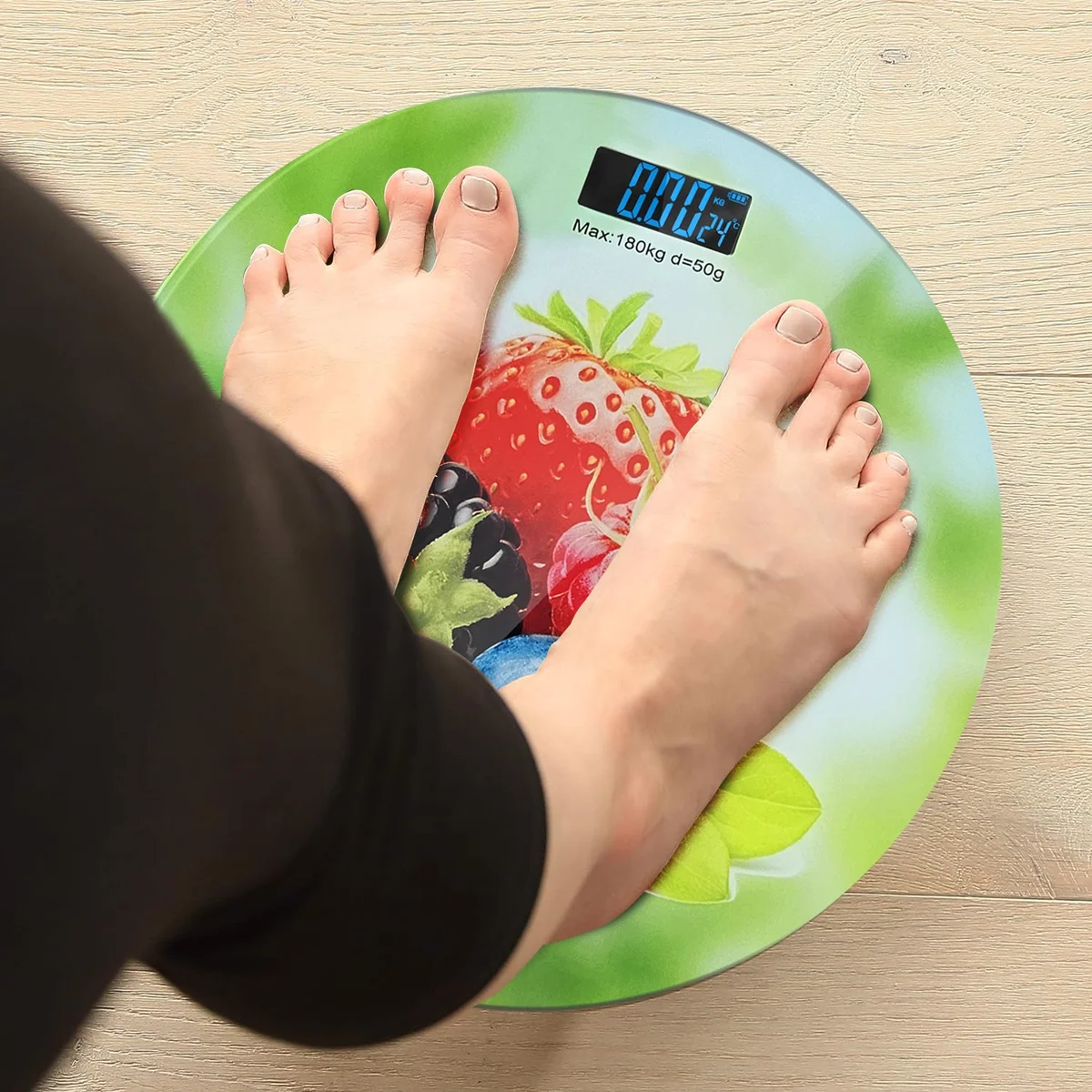 Round digital scales weight loss with printed design, LCD backlit display, and glass surface, measuring up to 180kg