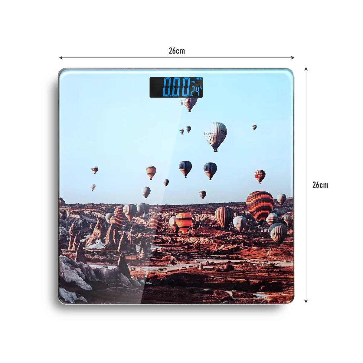 Square printed design scales with LCD display on tempered glass surface, showing weight reading in a bright room setting