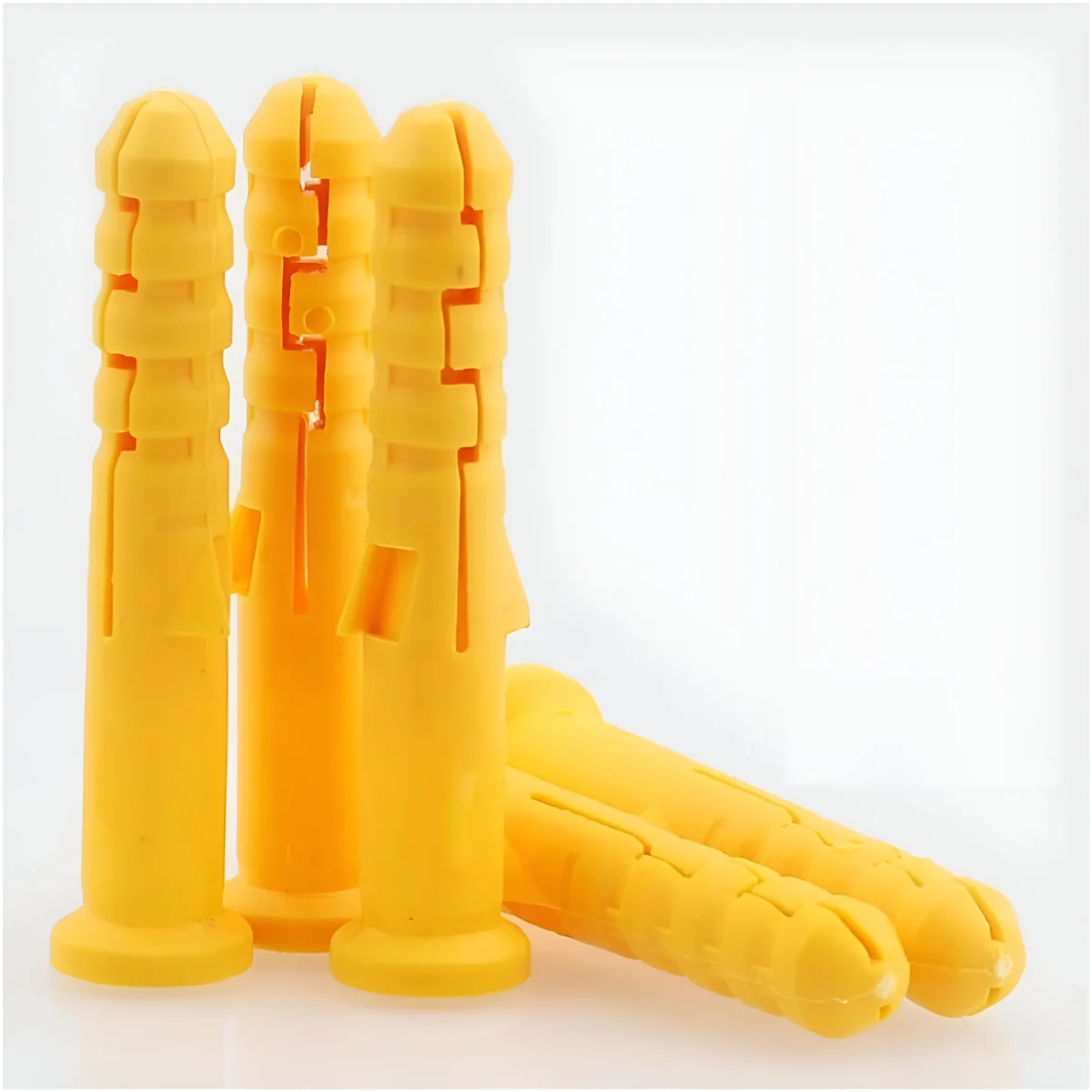 Anti slip wall plugs and flat head zinc-plated screws arranged on a white background for heavy-duty fixing tasks