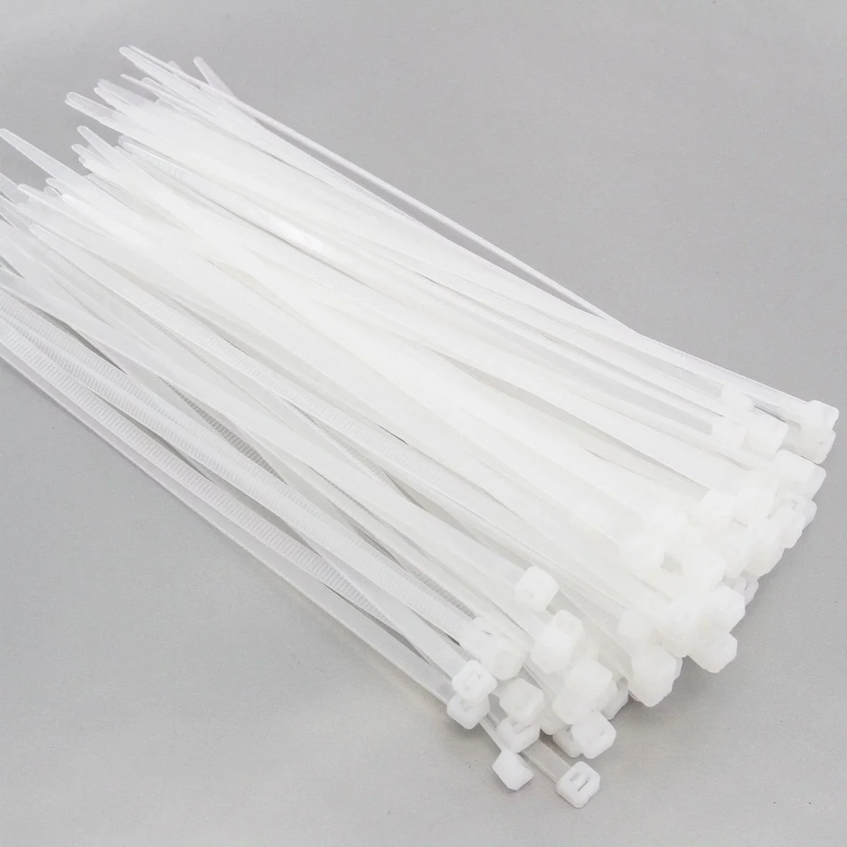 Bundle of 100 white cable ties made of durable nylon with self-locking zip design for cable management and organization