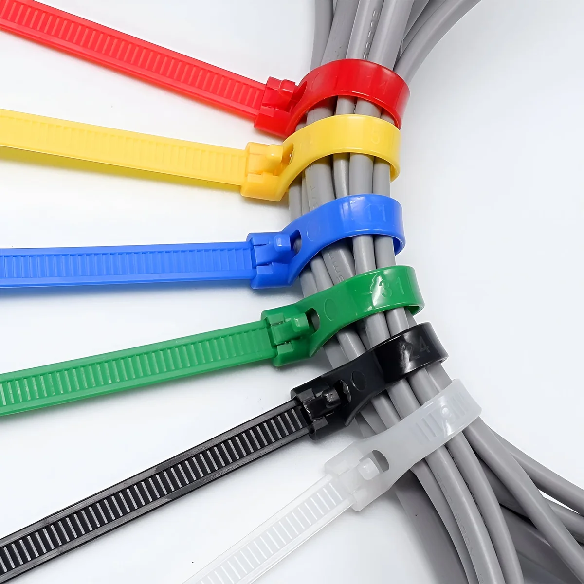 Pack of 100 reusable nylon releasable zip ties in a dark box, showing tied strips with rounded hooks