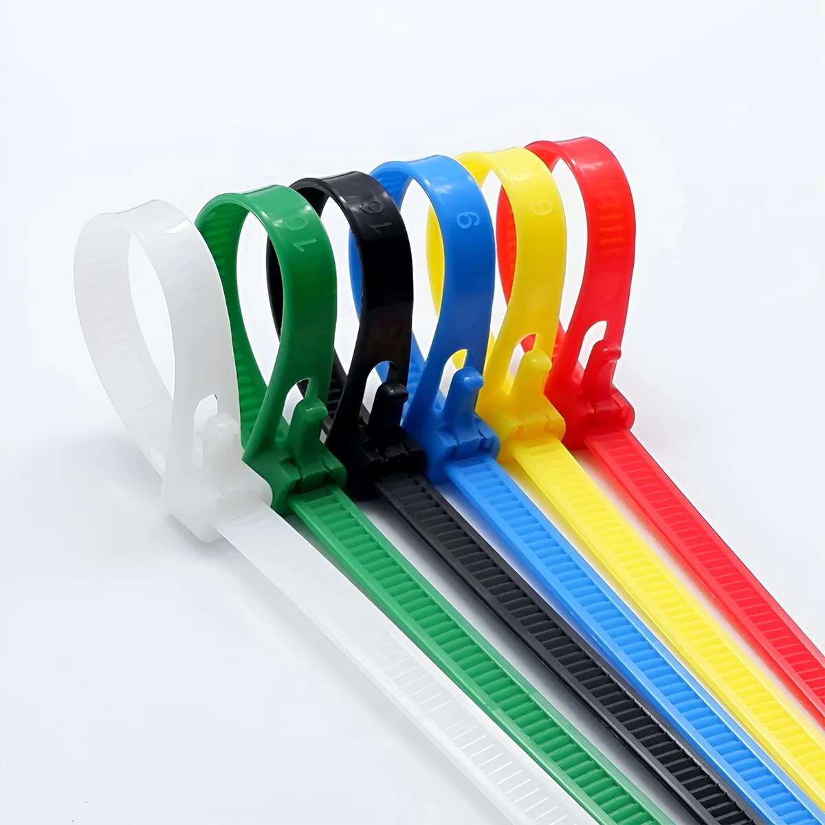 Metal cable ties next to 100 nylon zip ties, showing reusable locking teeth.
