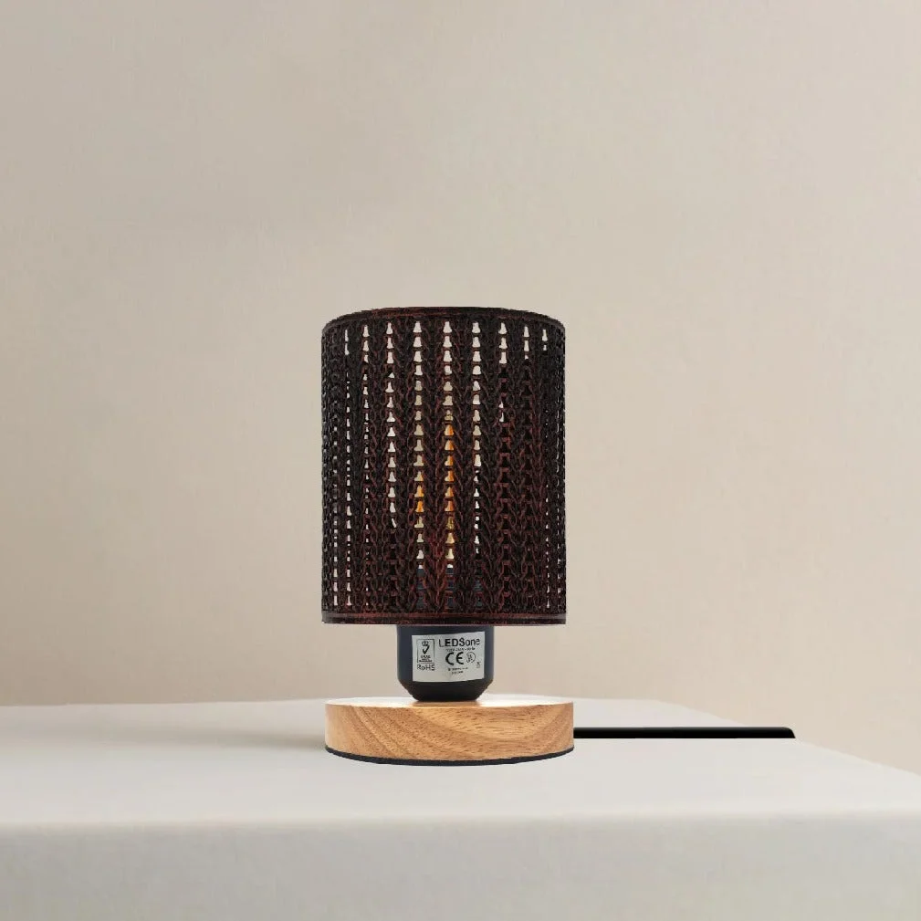 Industrial table lamp with metal wire cage shade and natural wood base on a white background