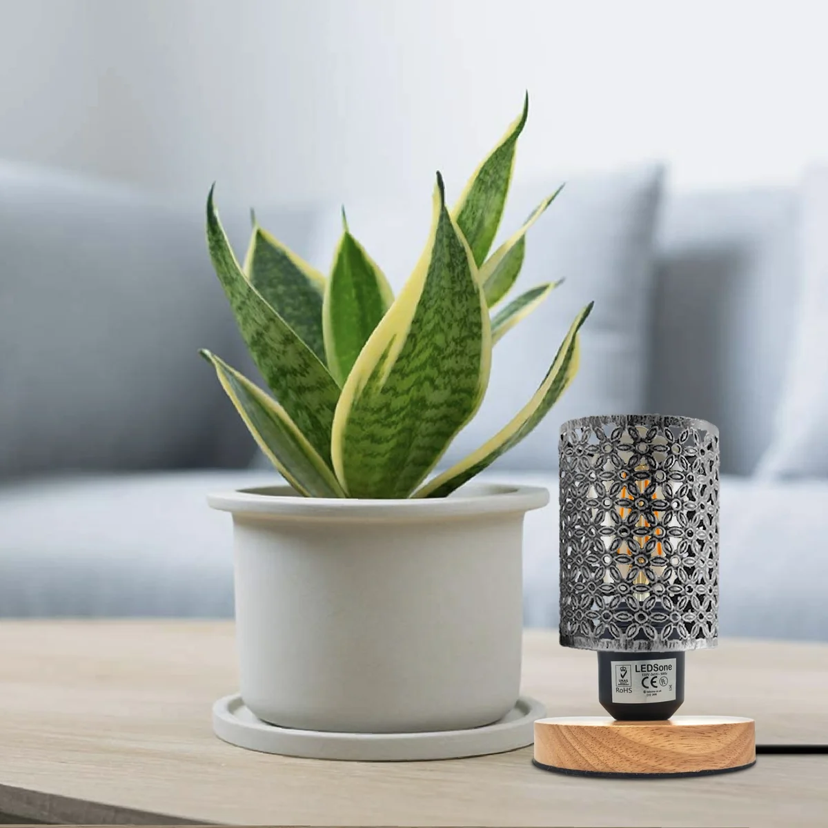 Retro style wood base lamp with metal wire cage shade on a wooden surface against a white background