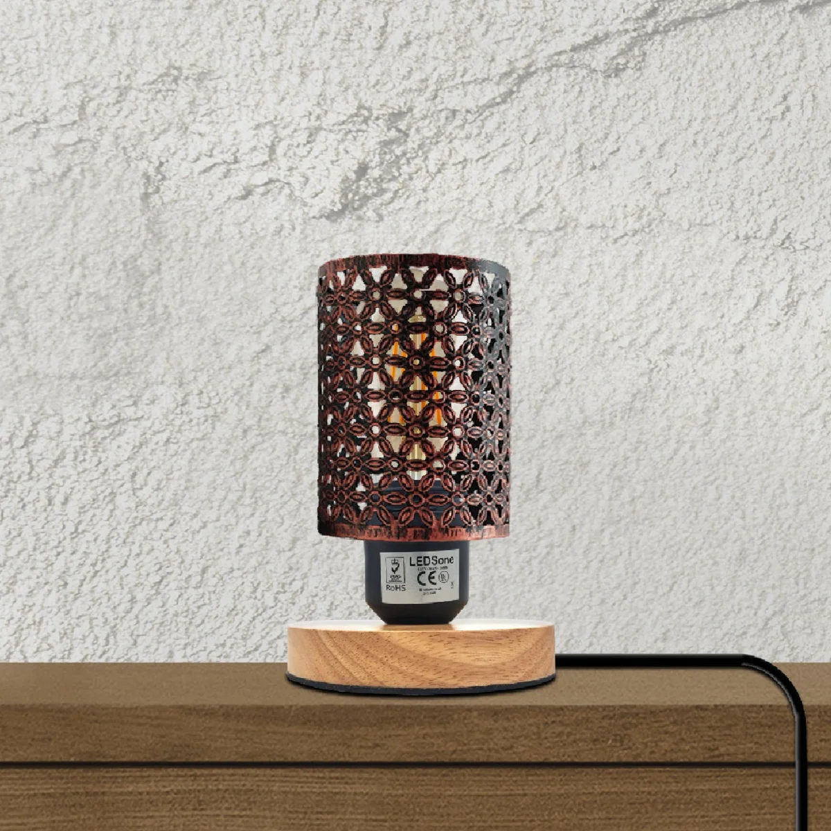 Retro industrial style lamp with metal wire cage shade and natural wood base on a wooden surface