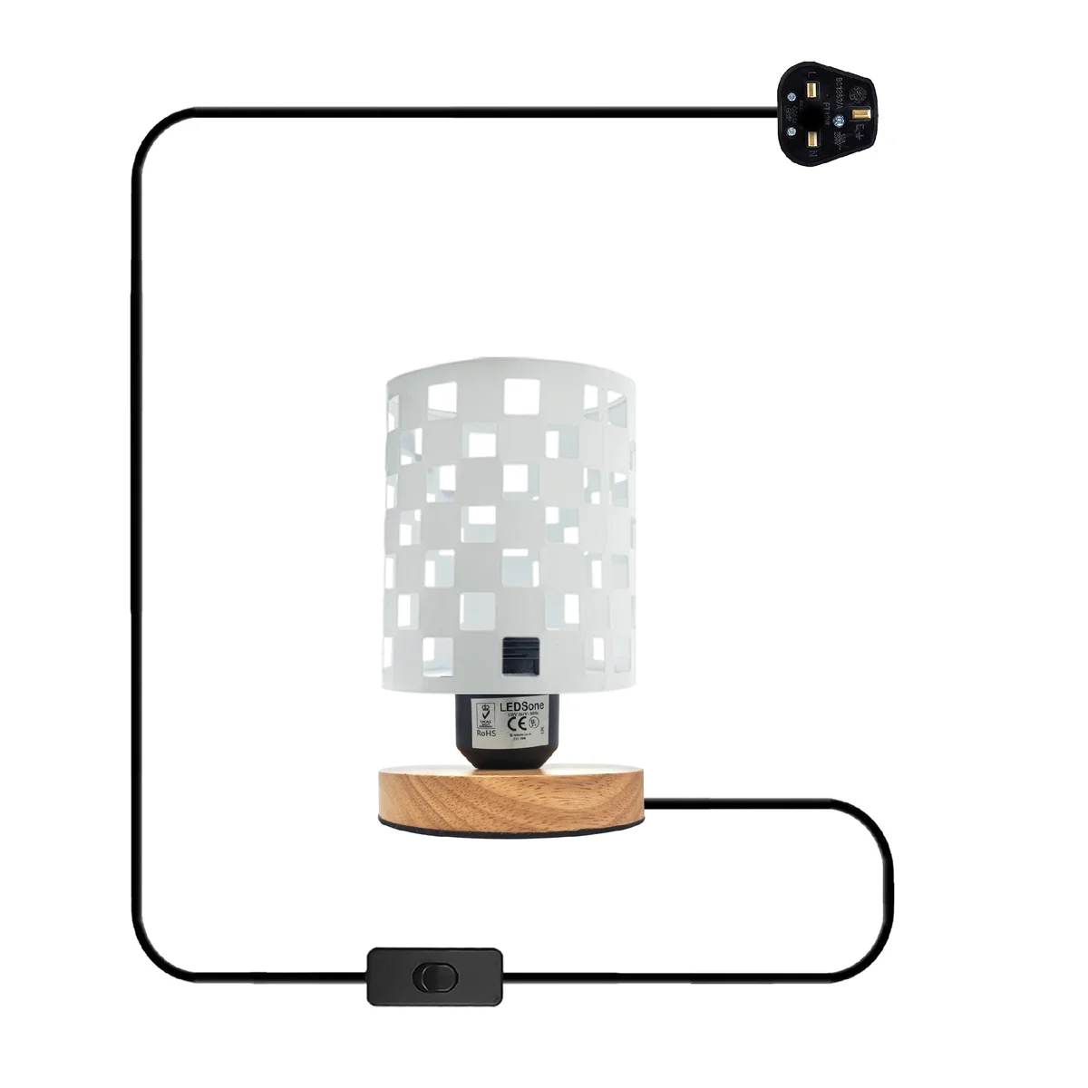 Antique brass bedside lamp with metal wire cage shade and natural wood base on a wooden surface against white wall