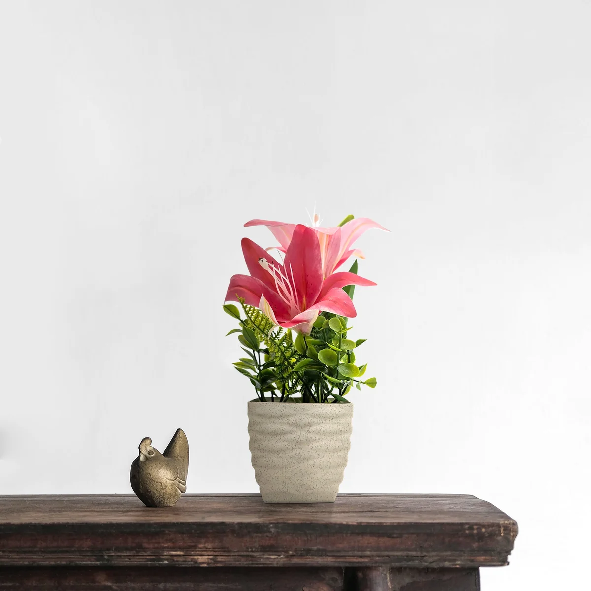 Two artificial lily flowers in pots with vibrant green leaves, ideal as an artificial flower pot for table decor