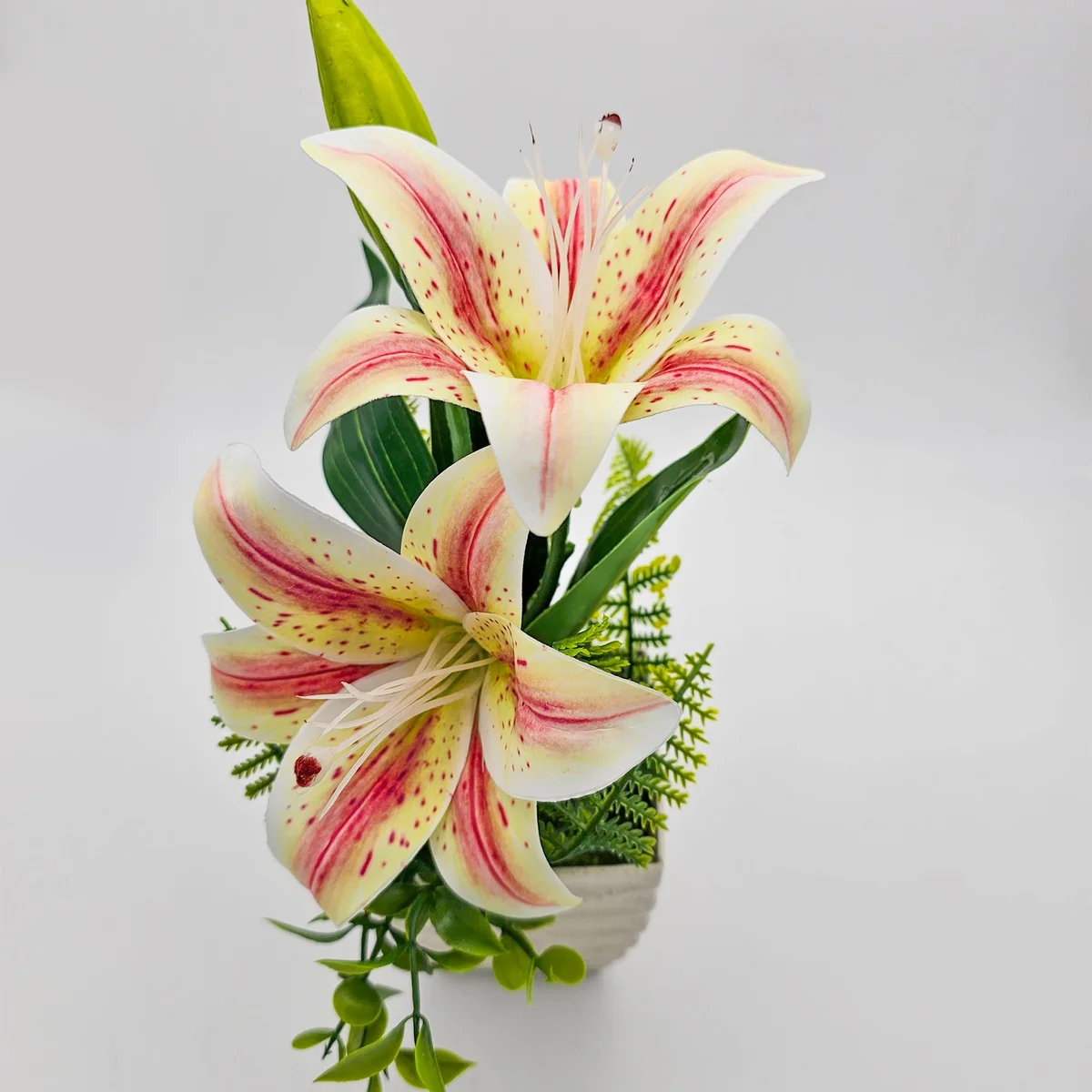 Two artificial lily flowers in pots with green leaves, ideal table decoration flowers for home or office use