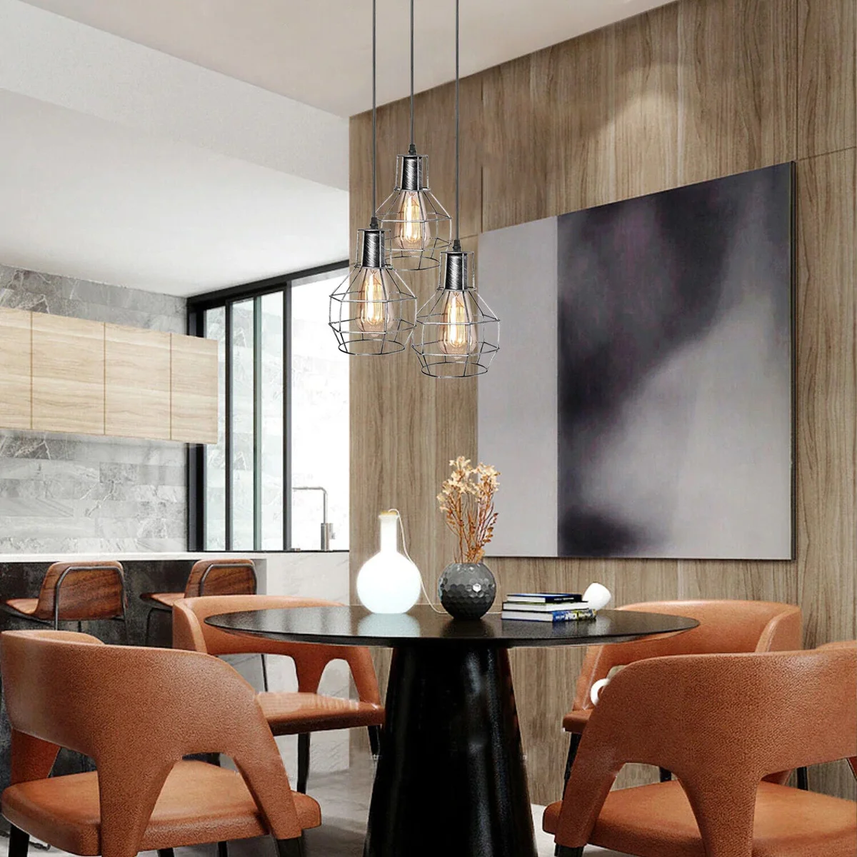 Three-light metal cage pendant light in brushed brass finish hanging with adjustable cables against white background