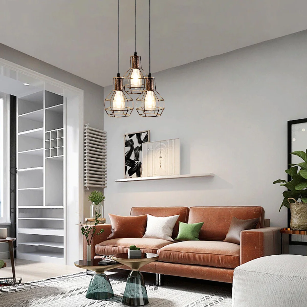 3-light pendant ceiling light with brushed brass cage design hanging from adjustable cables against white background