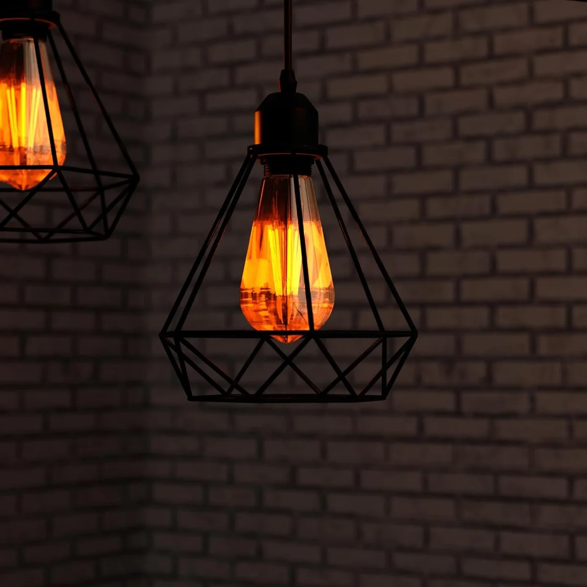 Black industrial pendant light with three diamond wire cages and adjustable cables hanging from ceiling fixture