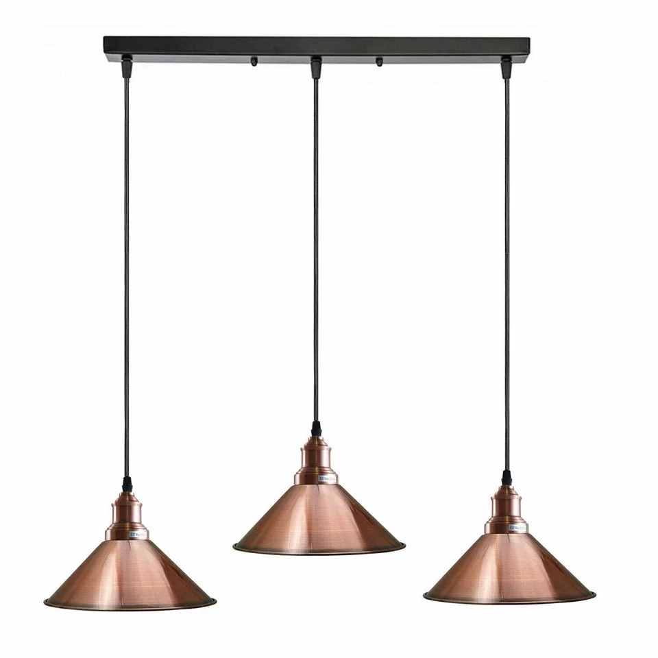 3 head pendant light with black metal holders and copper dome shades hanging from adjustable cables on a ceiling plate