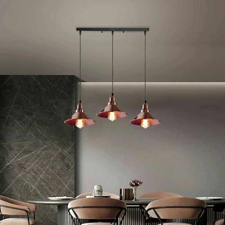 Three-head vintage industrial pendant light with copper shades and black metal fixtures hanging from ceiling plate