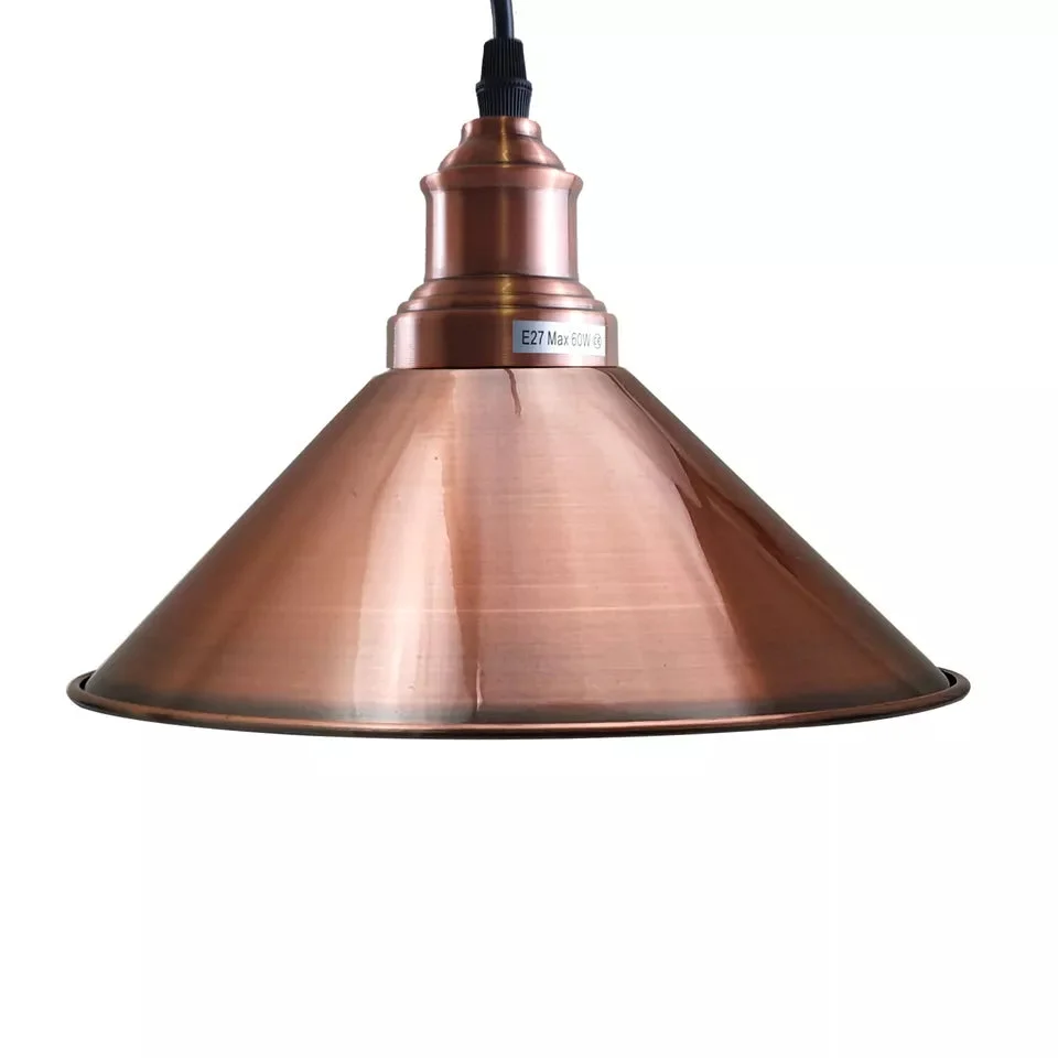 Three-head vintage industrial pendant light with black holder and copper shades hanging against white background