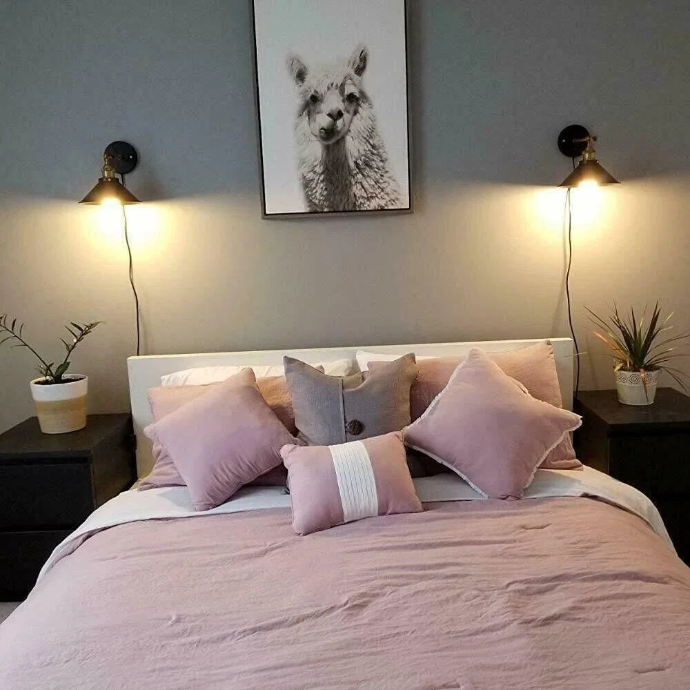 Vintage wall light with adjustable swivel arm and white cone shade mounted on a black metal base in industrial style