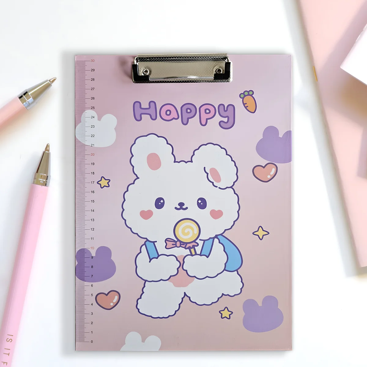 Set of four A4 cartoon clipboards with colorful playful designs and built-in ruler scale on plastic surface