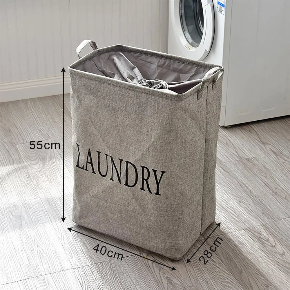 Foldable portable laundry bag in beige linen and cotton with handles, standing upright in a modern bedroom setting