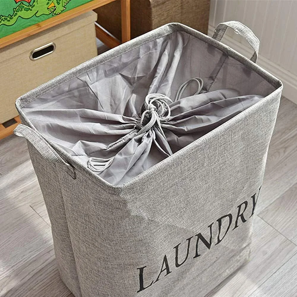 Foldable laundry bag in beige linen and cotton with handles, standing upright, showing spacious square design and drawstring closure