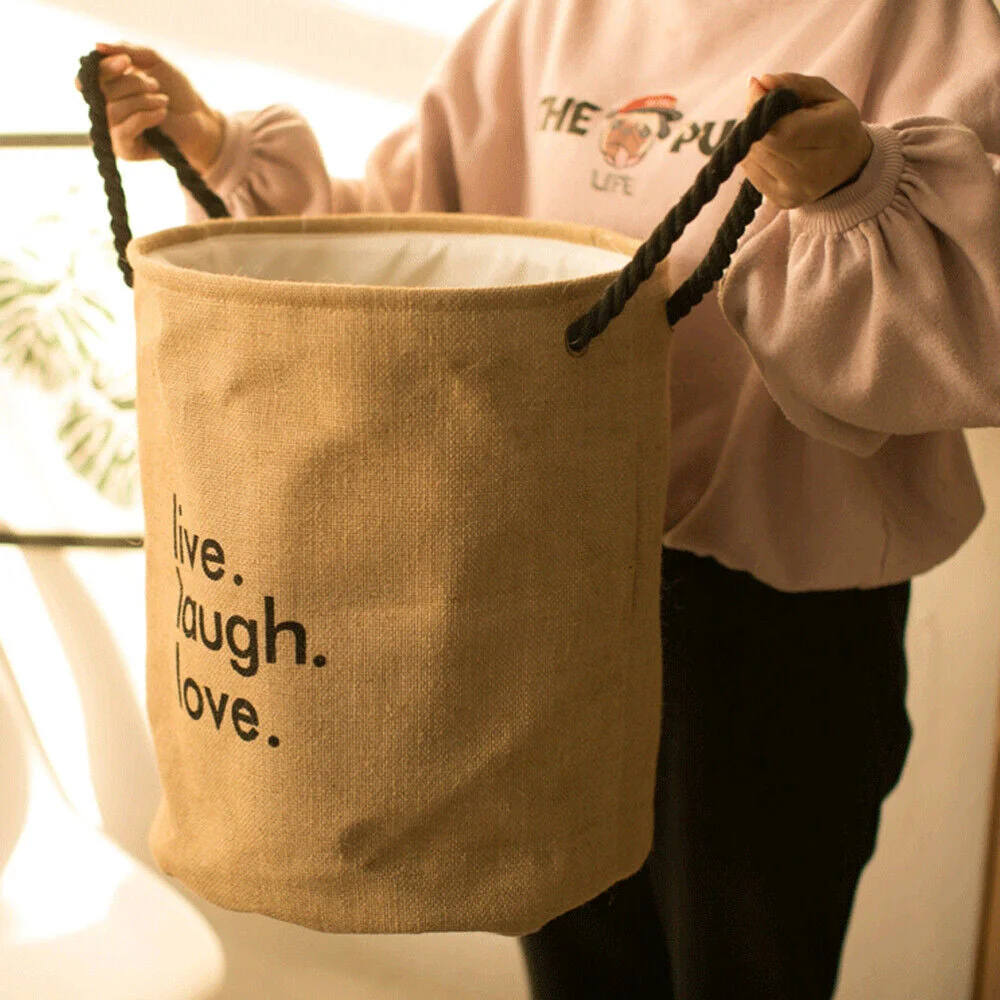 Large round foldable laundry bag made of jute with handles, standing upright, ideal for storing dirty clothes