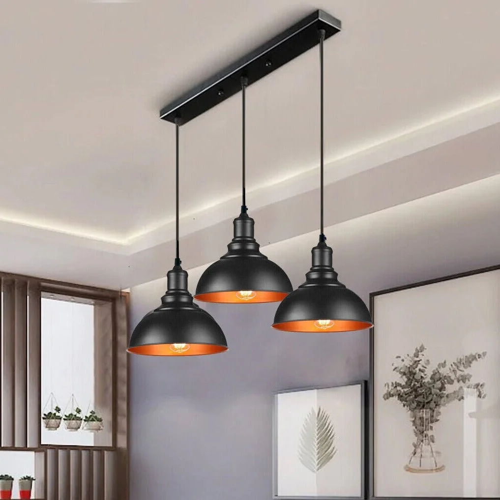Black industrial pendant ceiling light with three metal dome lampshades hanging from adjustable cables