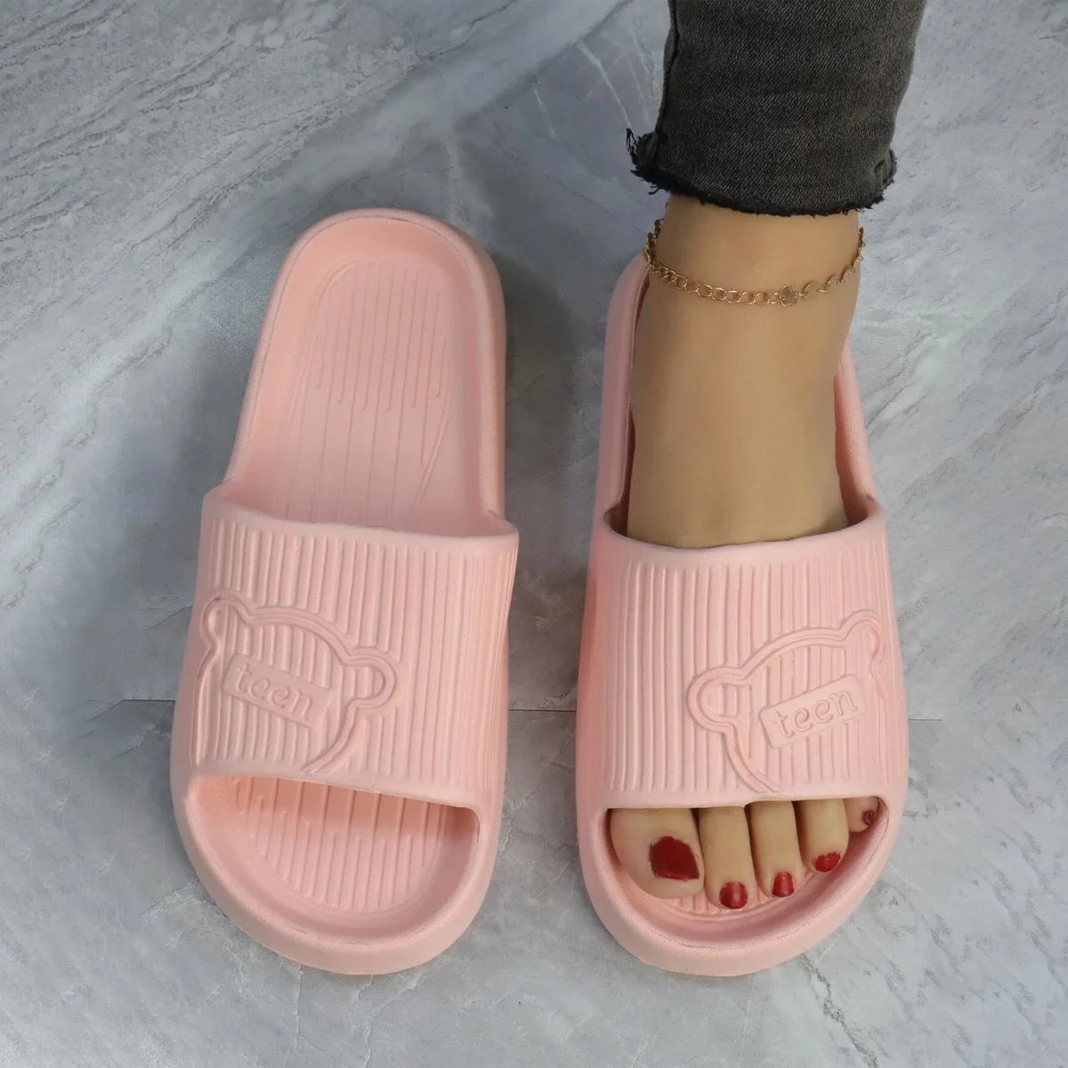 Pair of black indoor outdoor slippers with ergonomic design and non-slip soles on a white background